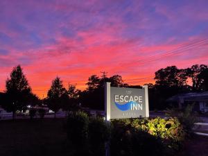 南雅茅斯艾斯凯普茵酒店的背景是日落的逃生旅馆的标志