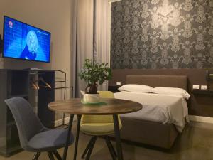米兰卡吕普索酒店的一间卧室配有一张床、一张桌子和一台电视。