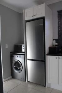 普利登堡湾Lux apartment Plett的厨房配有冰箱和洗衣机。