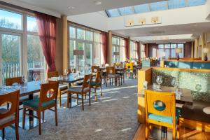 特尔福德The Telford Hotel, Spa & Golf Resort的餐厅设有桌椅和窗户。