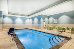 林垦Holiday Inn Express & Suites - Lincoln Downtown , an IHG Hotel的一个带桌椅的游泳池