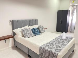 比利亚维哈Casa Hotel Estelar的一间卧室配有一张带灰色床头板和枕头的床。
