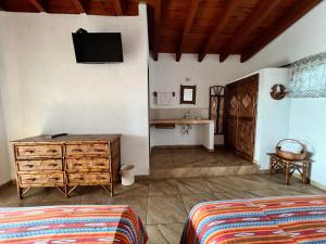 锡瓦塔塔内霍Villa el Arca的一间卧室配有梳妆台和墙上的电视