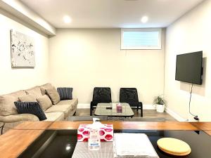 皮克灵Charming, Comfortable Bsmt Apartment in Pickering的带沙发和电视的客厅