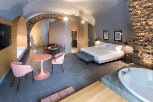 卡塔尼亚BASTIÒ PRIVATE SUITES的酒店客房配有一张床和浴缸。