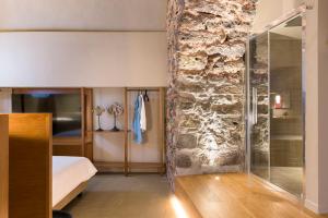卡塔尼亚BASTIÒ PRIVATE SUITES的一间卧室设有一张床和石墙