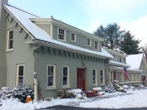 斯托Brass Lantern Inn的雪中带红门的房子