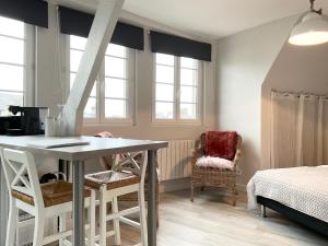 贝桑于潘港Mon Port d'Attache的客房设有桌椅和窗户。