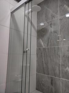 多明戈斯马丁斯Ipê Suítes的浴室里设有玻璃门淋浴