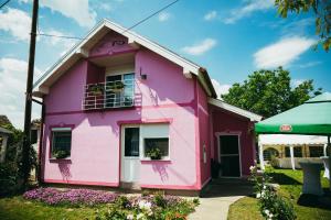 TenjaSobe "2 BORA"的粉红色的房子,有绿色的屋顶