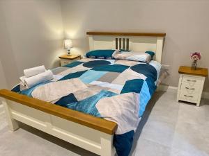 恩尼斯基林Erne Getaway No.6 Brand new 1 bed apartment的一间卧室配有一张带蓝色和白色棉被的床
