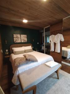 格拉玛多Vila Nambu - Exclusive Pousada的一间卧室配有一张大床和镜子