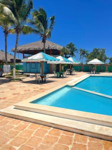 Puerto de LuperonPuerto Blanco Marina & Hotel的一个带遮阳伞的游泳池和一个度假村
