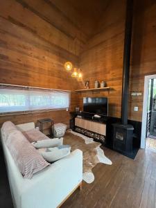 格拉玛多Vila Nambu - Exclusive Pousada的带沙发和壁炉的客厅