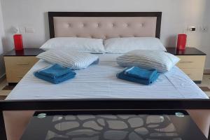 萨兰达Apartment Tinka in Saranda的一张大床,上面有两个蓝色的枕头