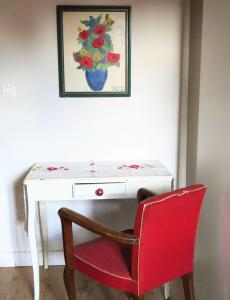 屈屈龙la dame jeanne的一张桌子,上面有红椅子和花瓶
