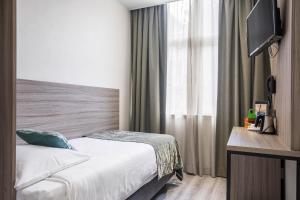 鹿特丹米兰诺酒店的酒店客房,配有床和电视