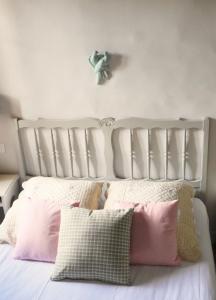 屈屈龙la dame jeanne的卧室内的白色床和粉红色枕头