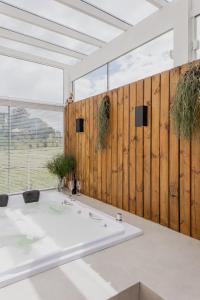 格拉玛多Vila Nambu - Exclusive Pousada的浴室配有白色浴缸和木墙