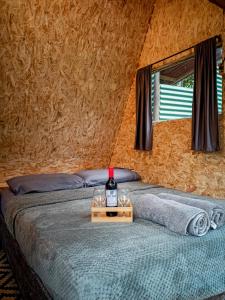 米卡ECO Cabin - TANOA Minca的卧室配有1瓶葡萄酒。