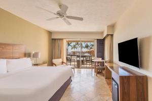 卡波圣卢卡斯盛大嘉年华美洲洛斯卡沃斯全包高尔夫温泉酒店的酒店客房设有床、电视和桌子。