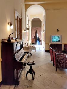 亚历山大Clement's House Hostel的客厅配有钢琴和桌子