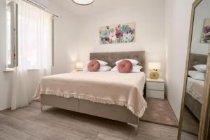 卡什泰拉Zora Residence的白色卧室配有一张带镜子的大床