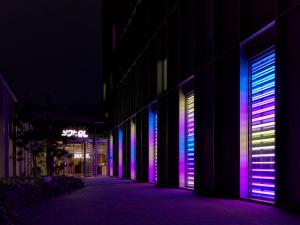 阿姆斯特丹YOTEL Amsterdam的一面有紫色和蓝色的灯光的建筑