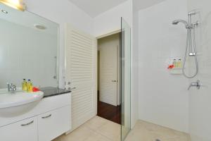 道格拉斯港鸡蛋花别墅的白色的浴室设有水槽和淋浴。