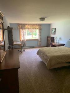 西南港Kenway Ranch的一间卧室配有一张床、一张书桌和一个窗户。