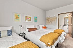 斯波坎New 2 Bed 2 Bath Near Perry District and DT的带3张白色床铺和橙色毯子的房间
