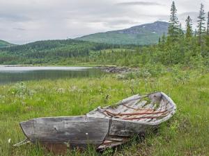 Holiday home KROKOM的木船坐在湖边的草地上