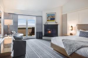 博德加湾The Lodge at Bodega Bay的酒店客房配有一张床和一个壁炉。