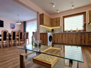 IwierzyceComfortable holiday home with swimming pool for 12 people, Iwierzyce的厨房以及带玻璃桌的用餐室