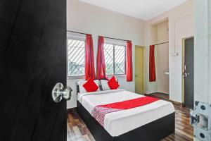 ChikalthānOYO Shree Balaji Lodging的一间卧室配有红色窗帘的床