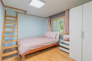 西归浦市艺术之家度假屋的一间卧室配有一张双层床和梯子