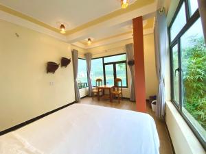峰牙Phong Nha Coco Riverside的一间卧室配有一张床和一张桌子及椅子