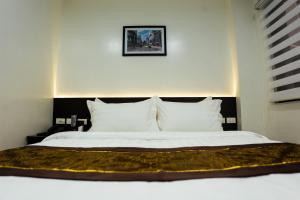 卡加盐德奥罗PRIMELUXE HOTEL的卧室配有一张带白色床单和枕头的大床。
