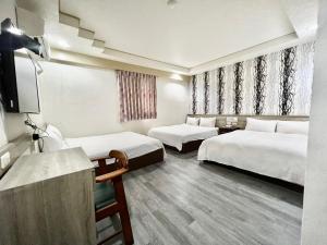 新竹WL HOTEL Hsinchu的酒店客房设有两张床和电视。
