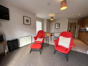 都柏林Sandymount House & Garden的客厅配有红色椅子和桌子