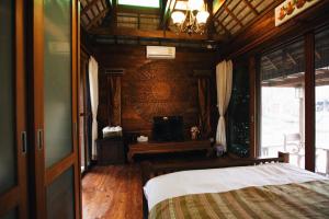 清迈班素万布利旅馆的一间卧室配有一张床和一个吊灯