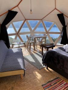 瓜塔维塔Glamping Vista Lago Guatavita的帐篷内带床和桌子的房间