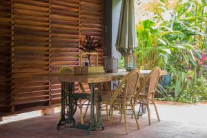 帕拉马里博Couleur Locale Paramaribo的庭院里配有一张带椅子和遮阳伞的木桌