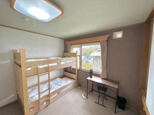 二世古Absolute Niseko Lodge的客房设有双层床、书桌和窗户。