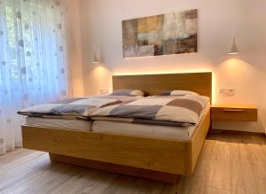 梅拉诺Neu, zentral, sonnig, Garage inklusive的一间卧室配有一张大床和木制床头板