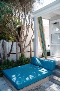 滨海肯顿Driftwood by The Oyster Collection的门廊上的蓝色沙发,带窗户