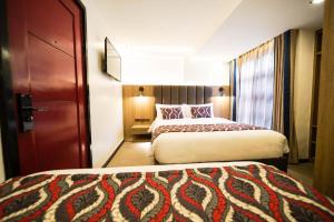 马尼拉UNWND Boutique Hotel Makati的一间酒店客房,设有两张床和一扇门