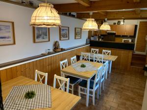 霍捷索瓦斯特拉Chata Jezevec的用餐室配有木桌、椅子和灯