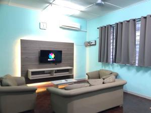 山打根Sandakan Homestay SEMi D 3R2B For 10Pax的客厅配有2张沙发和1台平面电视