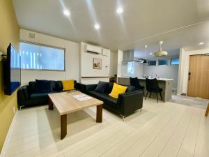 名古屋Villa Monica的客厅配有沙发和桌子